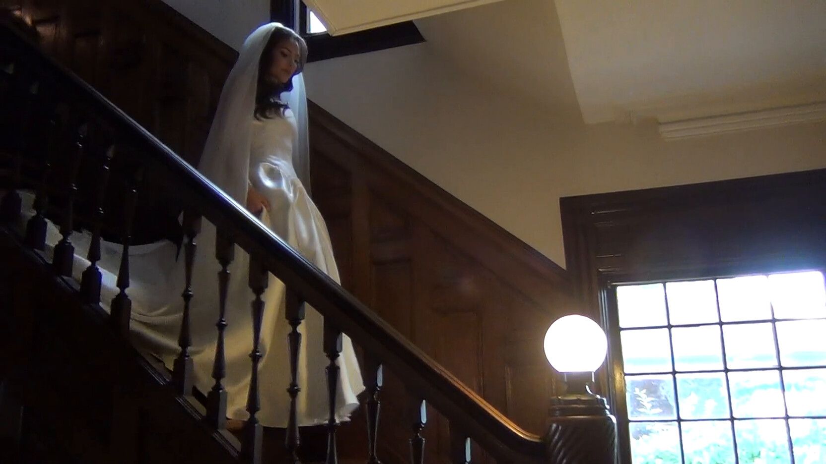 Bride coming down a staircase in low light, filmed on a Sony Handycam camcorder rental